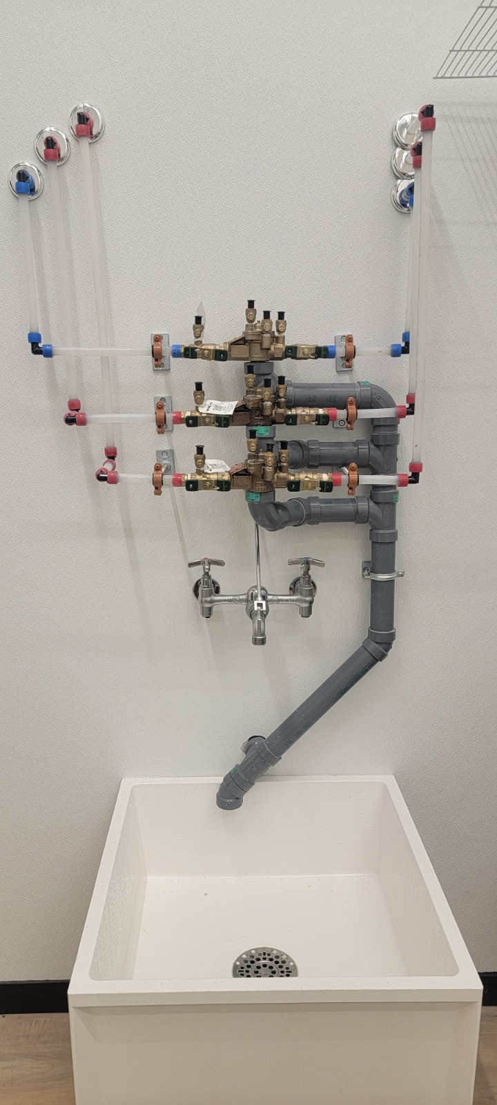 Backflow Water Valve — Commercial — Commercial backflow prevention valve assembly with isolation valves above a service sink.