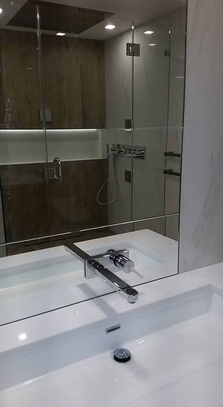Modern En-suite Package — Wall-mount basin faucet, concealed valves, and glass shower enclosure.