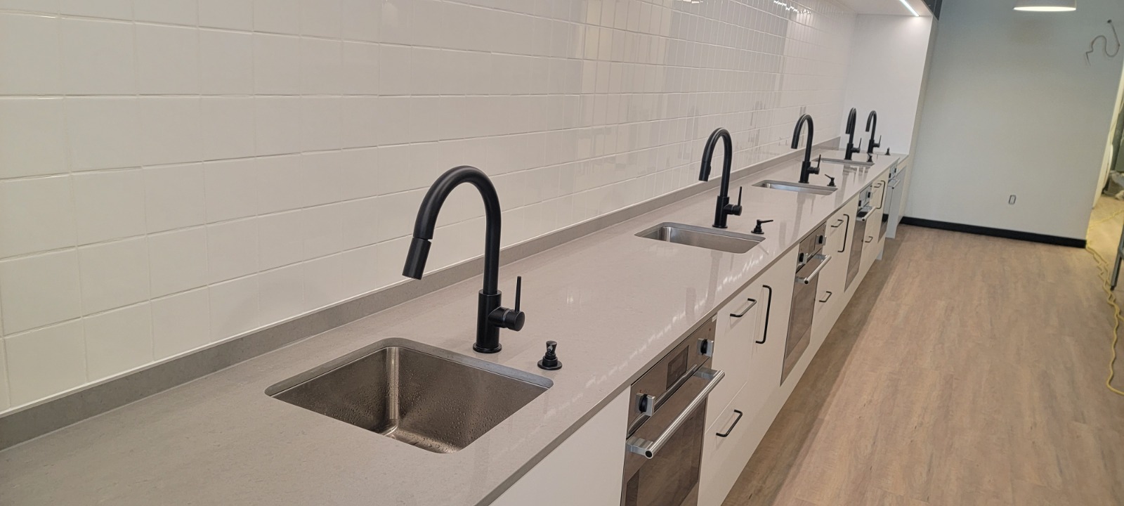 Sink Stations — Commercial — Row of commercial sink stations with undermount sinks.