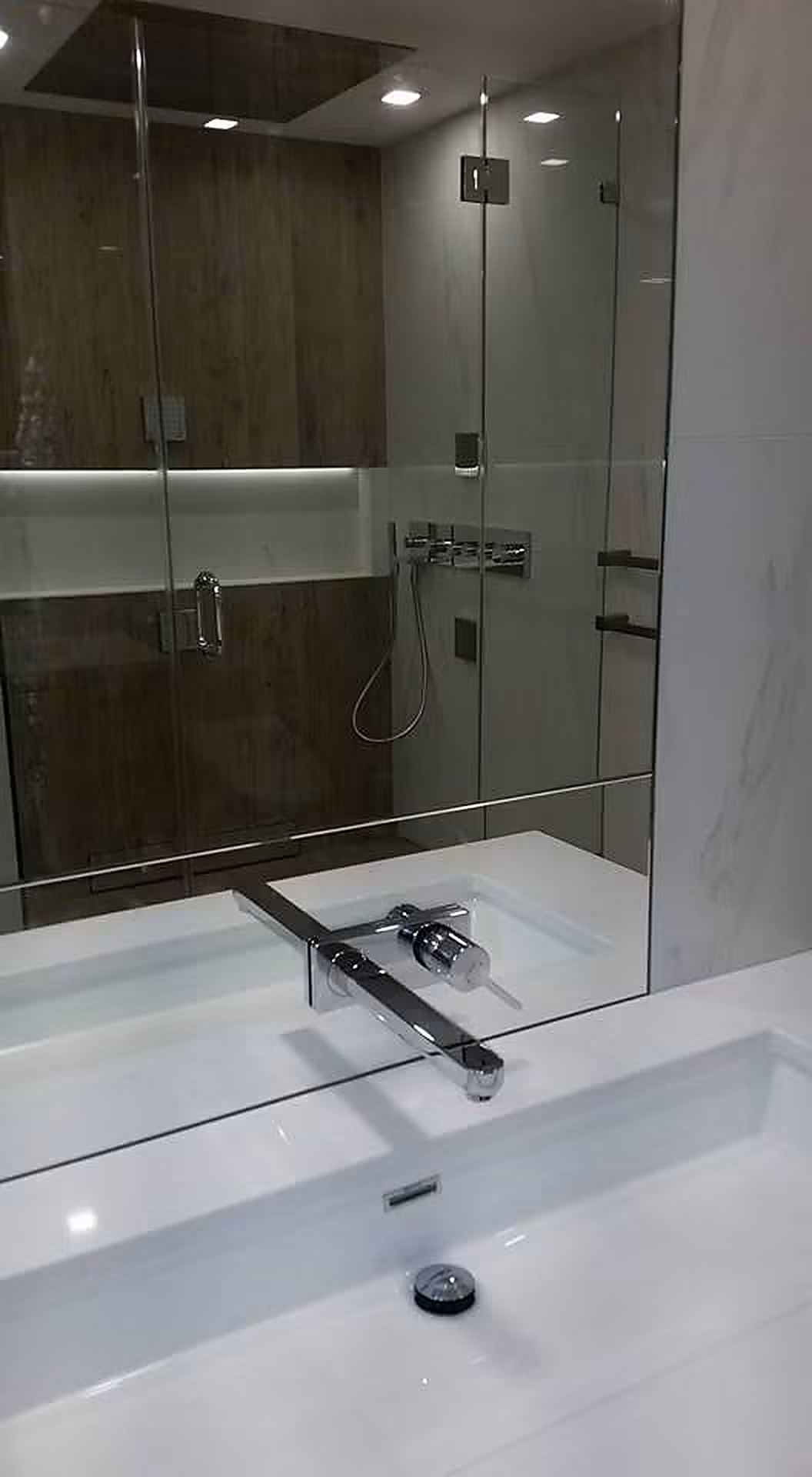 Modern En-suite Package — Wall-mount basin faucet, concealed valves, and glass shower enclosure.