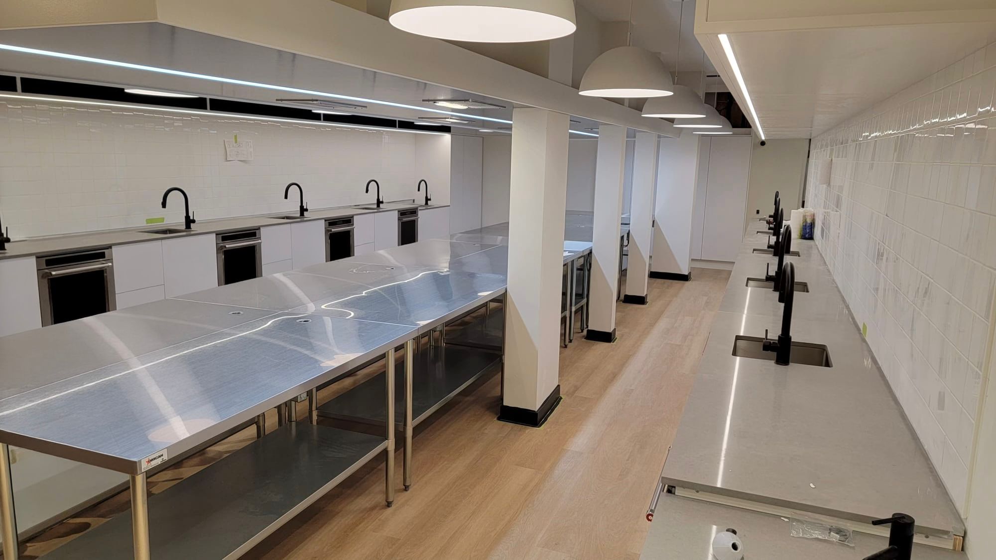 Commercial Sinks — New Build — Commercial kitchen sink run with wall-mount faucets and stainless prep stations.