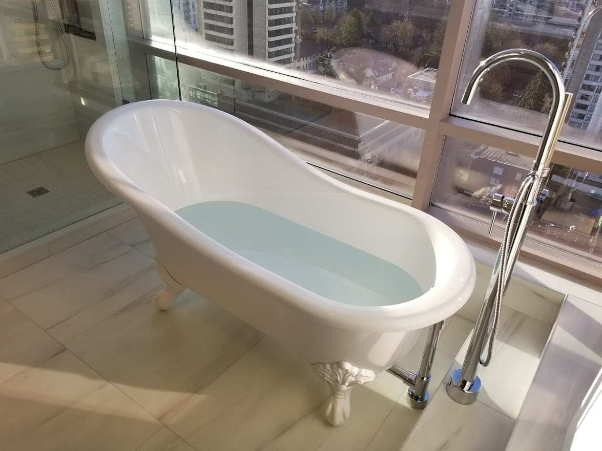 Clawfoot Tub — Vancouver Highrise — Freestanding clawfoot tub with floor-mount chrome filler installed in a downtown Vancouver highrise bathroom.