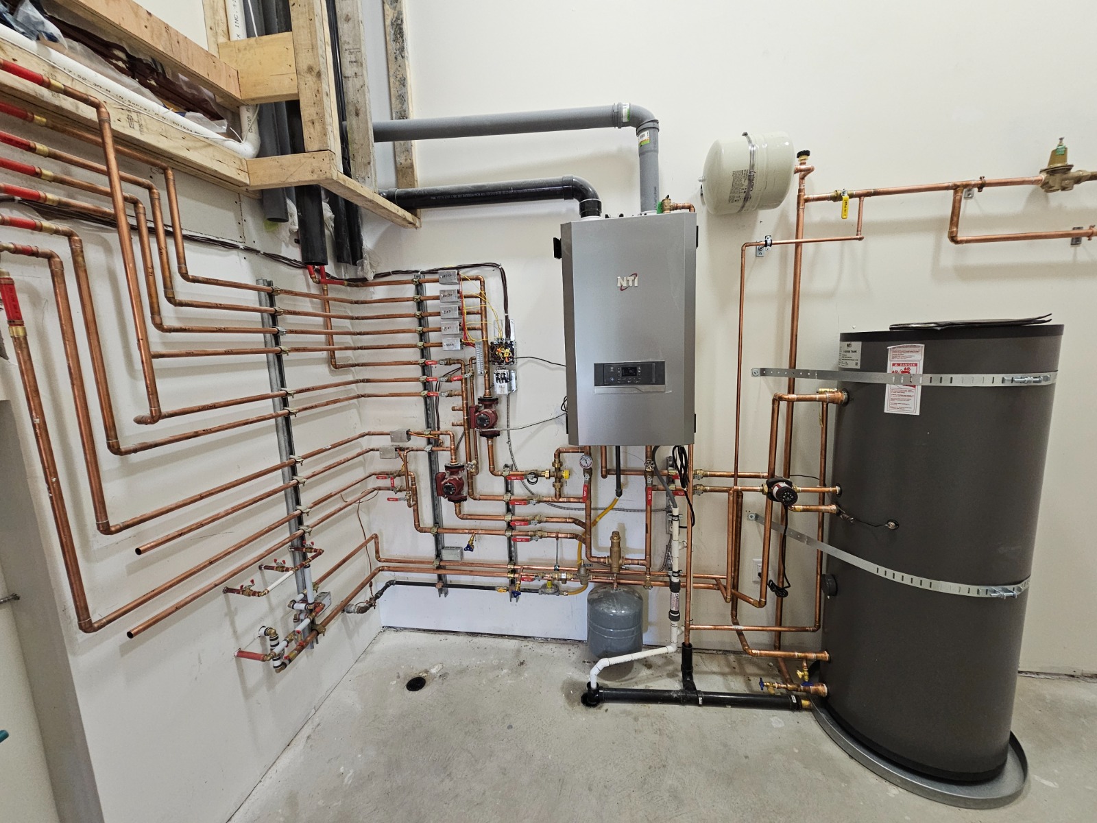 Mechanical Room — Residential — Wall-mounted boiler with copper distribution piping and hot water tank.